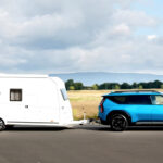 Camping mit E-Auto und Wohnwagen: So planen Sie Reichweite, Ladestopps und Anhängelast für einen entspannten Caravan-Urlaub.
